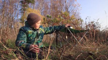 Çocuk uzun sarı çimenlerde oturur ve açgözlülükle yer..