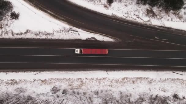 Camions et voitures voyagent rapidement le long de l'autoroute en hiver, vue aérienne. — Video