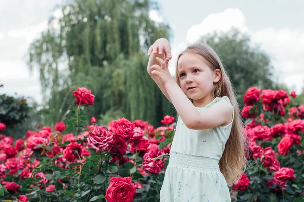 Mooie meisje in de bloeiende tuin maakt een gebaar — Stockfoto