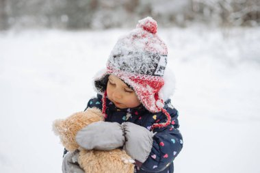 Tatlı küçük kız kar yağarken dışarıda oynarken eğleniyor. Karlı kış havası.