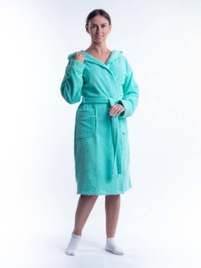 Yüzünde bir gülümseme olan, izole beyaz arka planda, bornozlu bir kadın. Stüdyoda tam gelişimle çekilmiştir..