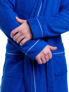 Parlak, banyo cüppeli bir adam beyaz bir arka planda kıyafet reklamları yapıyor. Stüdyoda yakın çekim..