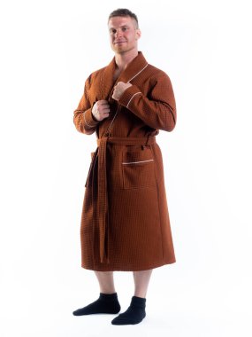 Yüzünde bir gülümseme olan beyaz bir arka planda, bornozlu güçlü bir adam. Stüdyoda tam gelişimle çekilmiştir..