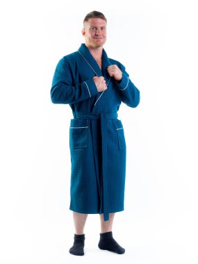 Yüzünde bir gülümseme olan beyaz bir arka planda, bornozlu güçlü bir adam. Stüdyoda tam gelişimle çekilmiştir..