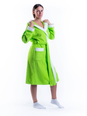 Yüzünde bir gülümseme olan, izole beyaz arka planda, bornozlu bir kadın. Stüdyoda tam gelişimle çekilmiştir..