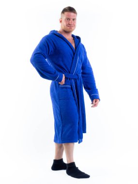 Yüzünde bir gülümseme olan beyaz bir arka planda, bornozlu güçlü bir adam. Stüdyoda tam gelişimle çekilmiştir..