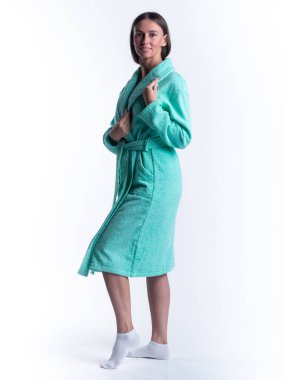 Yüzünde bir gülümseme olan, izole beyaz arka planda, bornozlu bir kadın. Stüdyoda tam gelişimle çekilmiştir..