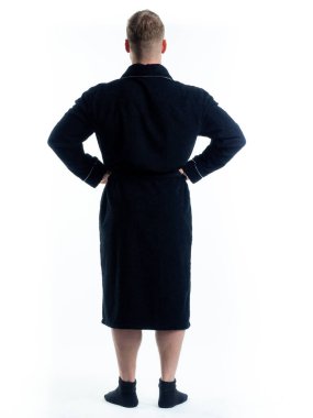 Arkadan bornozlu bir adam izole edilmiş beyaz bir arka planda. Stüdyoda tam gelişimle çekilmiştir..