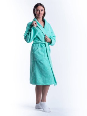 Yüzünde bir gülümseme olan, izole beyaz arka planda, bornozlu bir kadın. Stüdyoda tam gelişimle çekilmiştir..