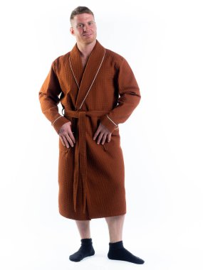 Yüzünde bir gülümseme olan beyaz bir arka planda, bornozlu güçlü bir adam. Stüdyoda tam gelişimle çekilmiştir..