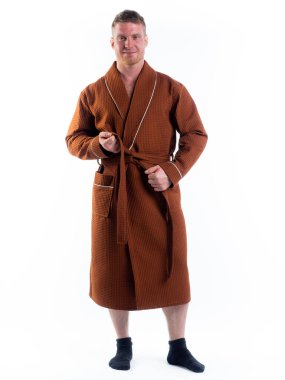 Yüzünde bir gülümseme olan beyaz bir arka planda, bornozlu güçlü bir adam. Stüdyoda tam gelişimle çekilmiştir..