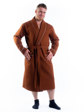 Yüzünde bir gülümseme olan beyaz bir arka planda, bornozlu güçlü bir adam. Stüdyoda tam gelişimle çekilmiştir..