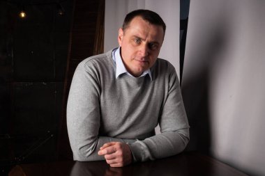 Takım elbiseli yakışıklı bir adam stüdyoda poz veriyor. Kameraya bak.