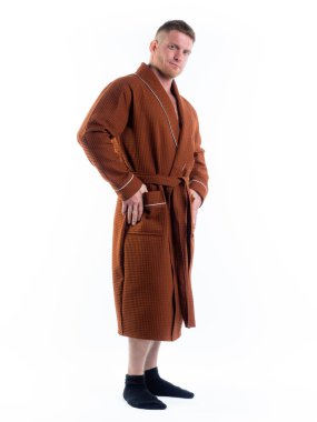 Yüzünde bir gülümseme olan beyaz bir arka planda, bornozlu güçlü bir adam. Stüdyoda tam gelişimle çekilmiştir..