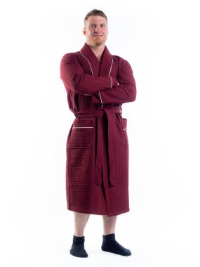 Yüzünde bir gülümseme olan beyaz bir arka planda, bornozlu güçlü bir adam. Stüdyoda tam gelişimle çekilmiştir..