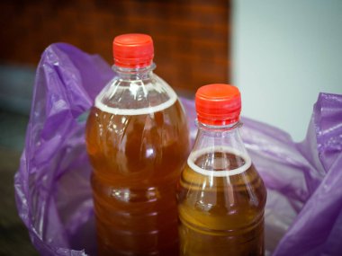 Süpermarkette bir satıcı elinde bir paket bira tutuyor. Plastik bir çantada.