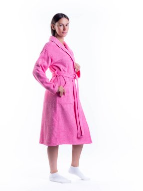 Yüzünde bir gülümseme olan, izole beyaz arka planda, bornozlu bir kadın. Stüdyoda tam gelişimle çekilmiştir..