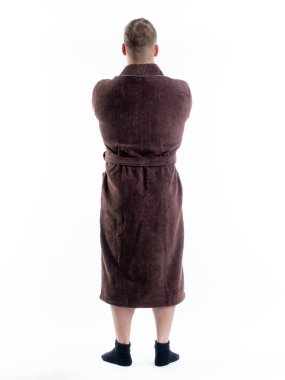 Arkadan bornozlu bir adam izole edilmiş beyaz bir arka planda. Stüdyoda tam gelişimle çekilmiştir..