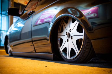 Araba gece sokağa yakın bir yerde park edilmiş. Gece konsepti, daha düşük bir çıtayla araba kullanmaktır..