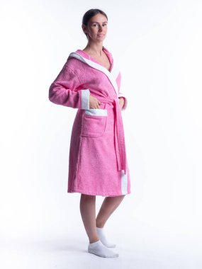 Yüzünde bir gülümseme olan, izole beyaz arka planda, bornozlu bir kadın. Stüdyoda tam gelişimle çekilmiştir..