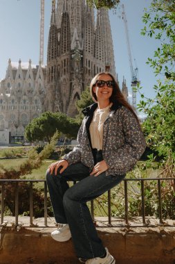 Sagrada Familia 'da yeşil gölette oturan genç bir kadın.