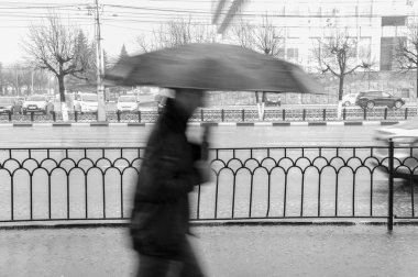 Bir şemsiye altında yürüyen adam