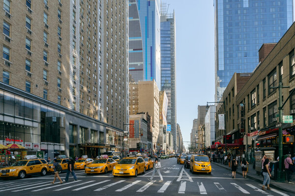 New York, USA - September 20, 2015: People and yellow taxi on the street of New York.