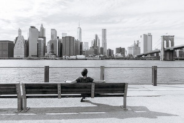 New York, USA - September 21, 2015: The man sits on the bench and admire of the downtown of New York.
