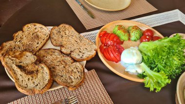 Avokado domatesli Mozzarella peyniri ve tabakta marul yaprağı..