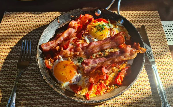Kızarmış jambonlu ve yumurtalı köy kahvaltısı kızartma tavasında pişirilir..