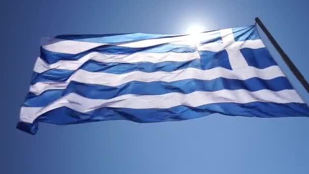 Grecka flaga tańczy na wietrze w zwolnionym tempie, w pięknym Santorini, Grecja. — Wideo stockowe