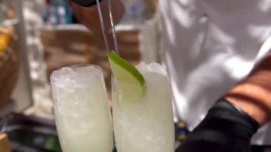 Barmen, limon, tonik ve buzla Alkolik Kokteyli Hazırlıyor.