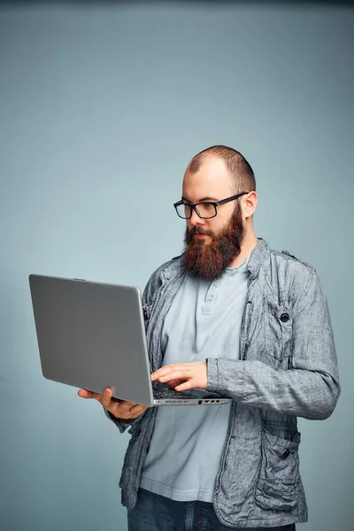 lifestyle successful freelancer man with beard achieves new goal with laptop in loft interior