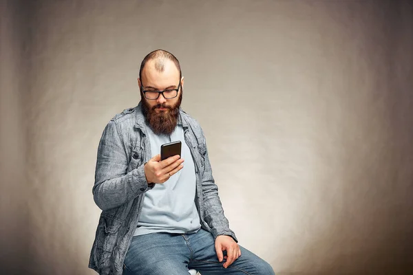 mobile technology and digital device addiction. smiling man holding phone.