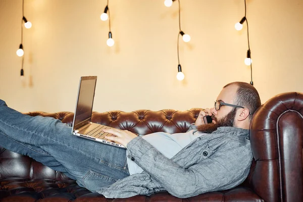 lifestyle successful freelancer man with beard achieves new goal with laptop in loft interior.