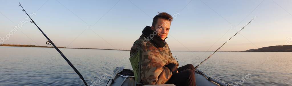 Teen boy drives a motorised PVC boat, fishing on trolling — Stock Image Teen Boy Drives Motorised Pvc Boat Fishing Trolling Stock Image