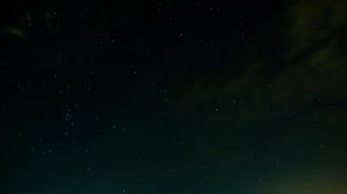 Gece gökyüzünde yıldızlar ve bazı bulutlar ile