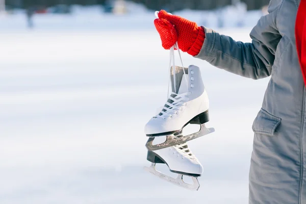 Young woman showing ice skates for winter — Stock Photo, Image