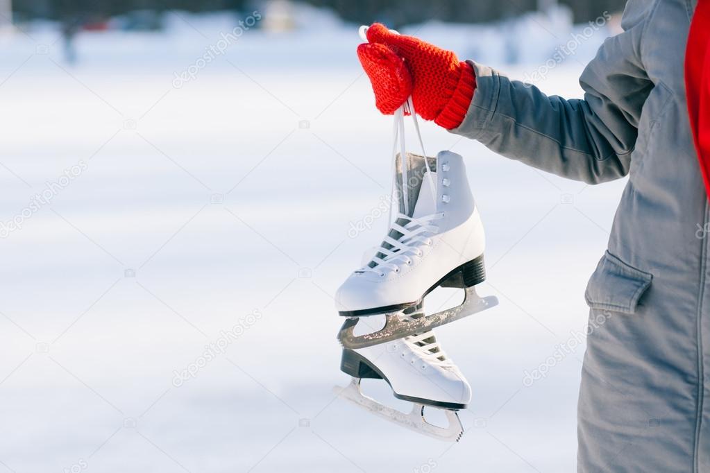 Young woman showing ice skates for winter 