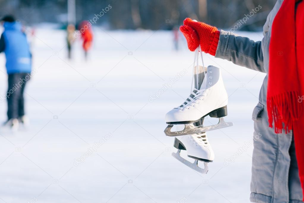 Young woman showing ice skates for winter 