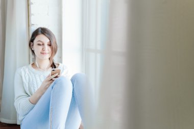 Genç kadın bir sms cep telefonu üzerinde okur.