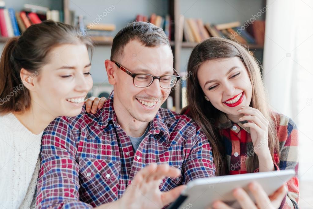 smiling students looking at tablet