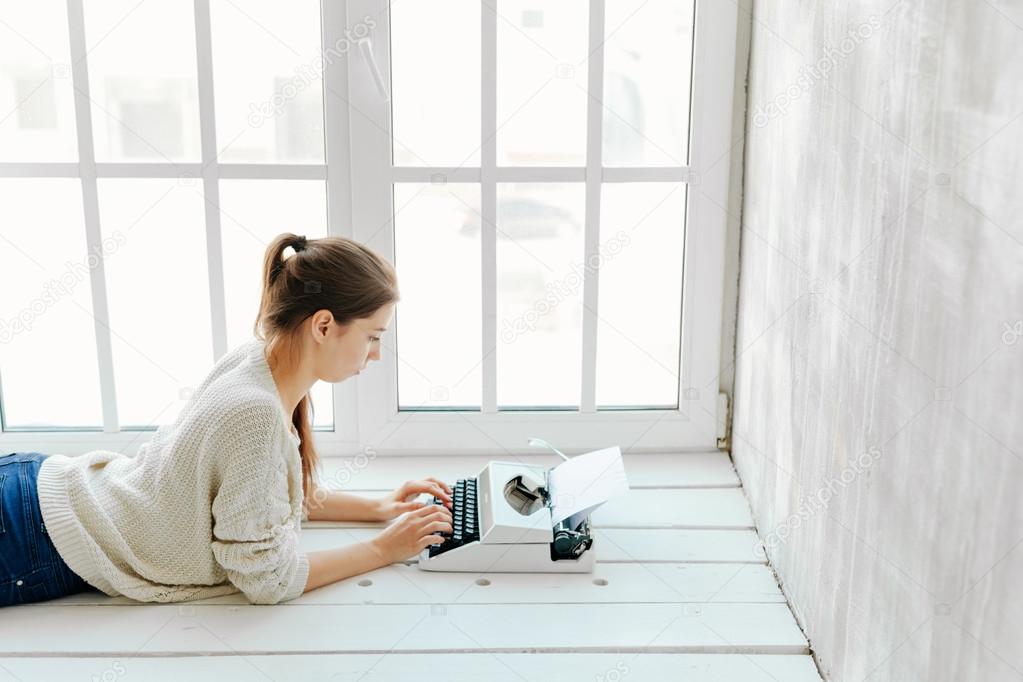 womans hand typing on retro machine