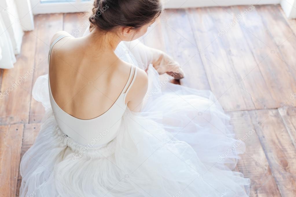 Young ballerina standing on poite at barre in ballet class