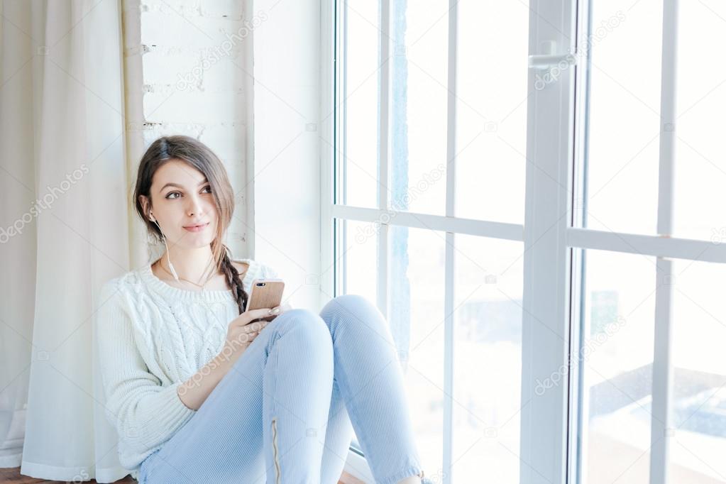 Young woman reads an sms on her mobile phone 