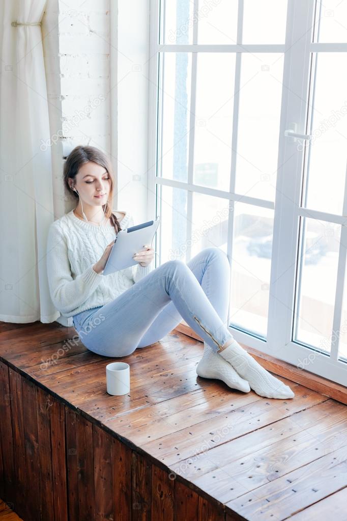 Young beautiful long hair woman using tablet computer indoor.