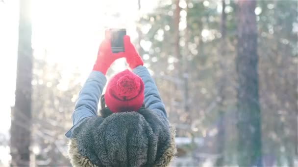 Tjejen gör en selfi på vintern i solnedgången — Stockvideo
