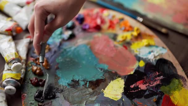 Primer plano del pincel en las manos de la mujer mezclando pinturas en la paleta — Vídeos de Stock