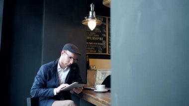 genç adam bir kafede, tablet bilgisayar kullanma