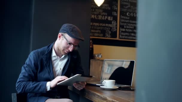 若い男がカフェでタブレット コンピューターを使用して — ストック動画